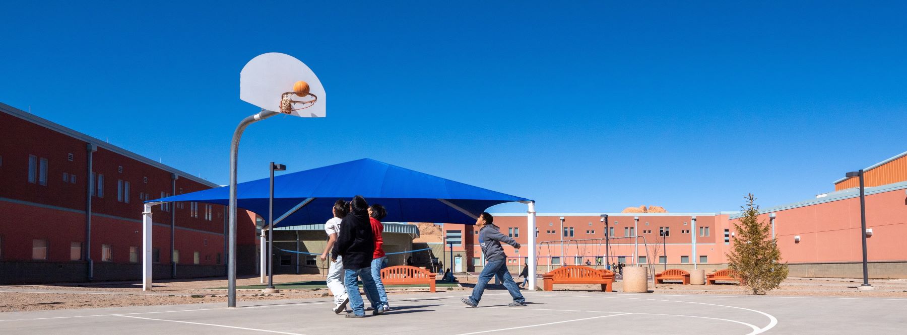 Several players are on a basketball court, actively playing and trying to score points in a game.