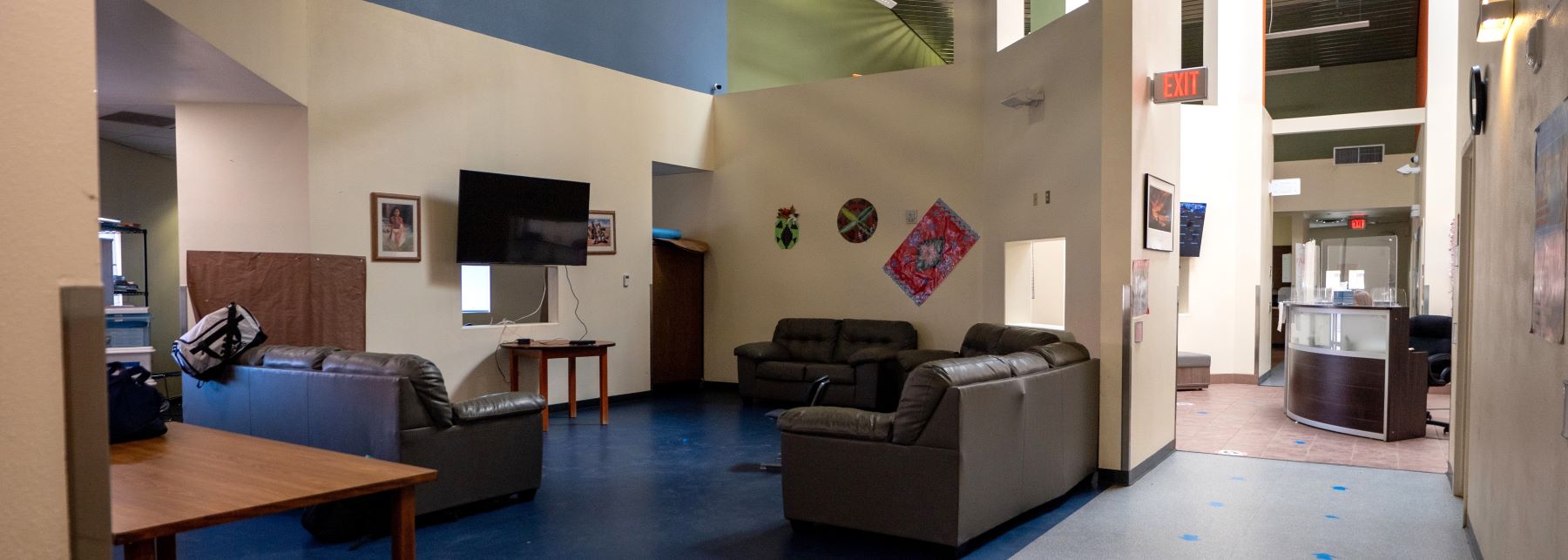 The school lobby showcasing a vibrant blue floor, with stylish furniture and open space for visitors.